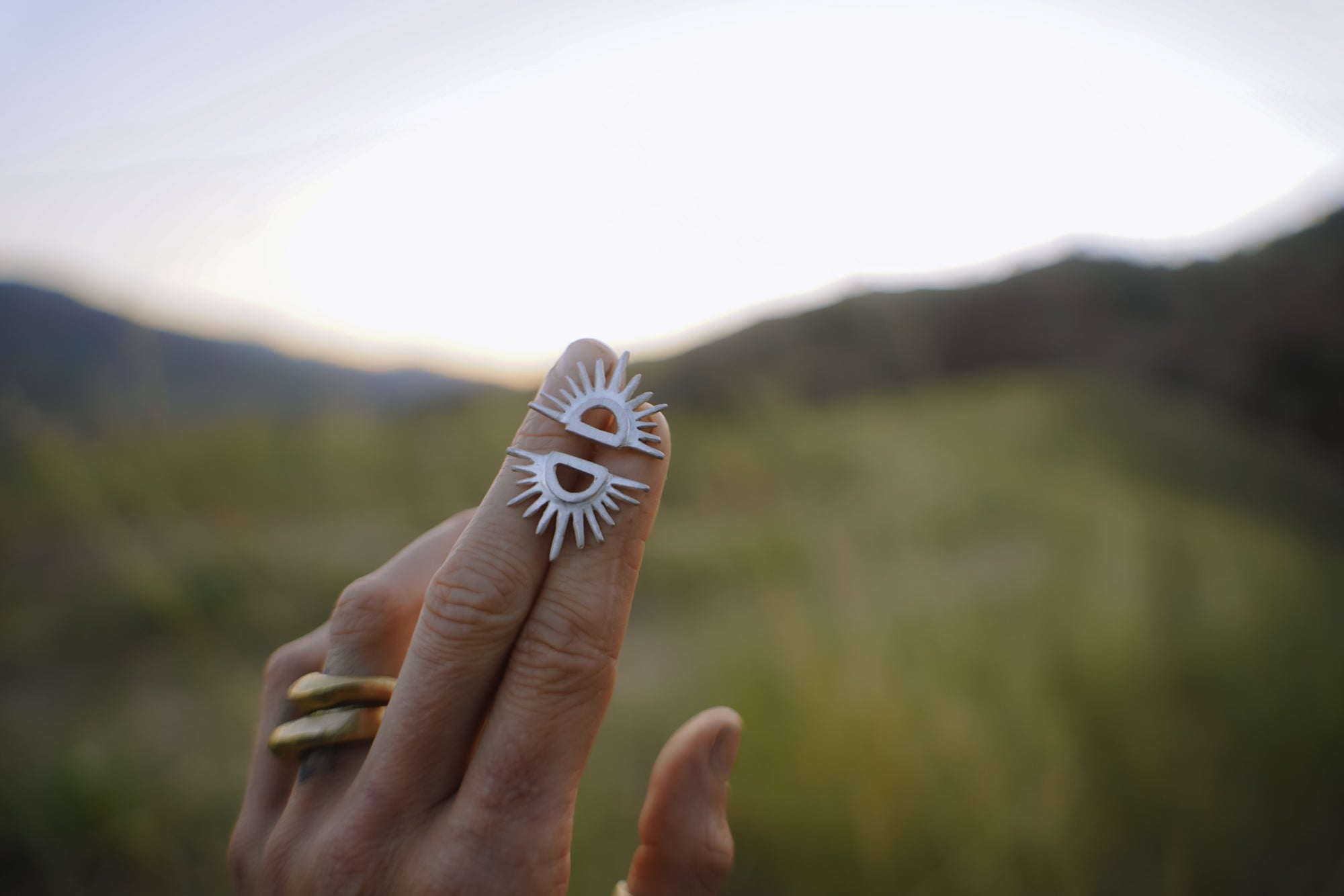 Reclaimed sterling silver post earrings that resemble the setting sun at the horizon line.