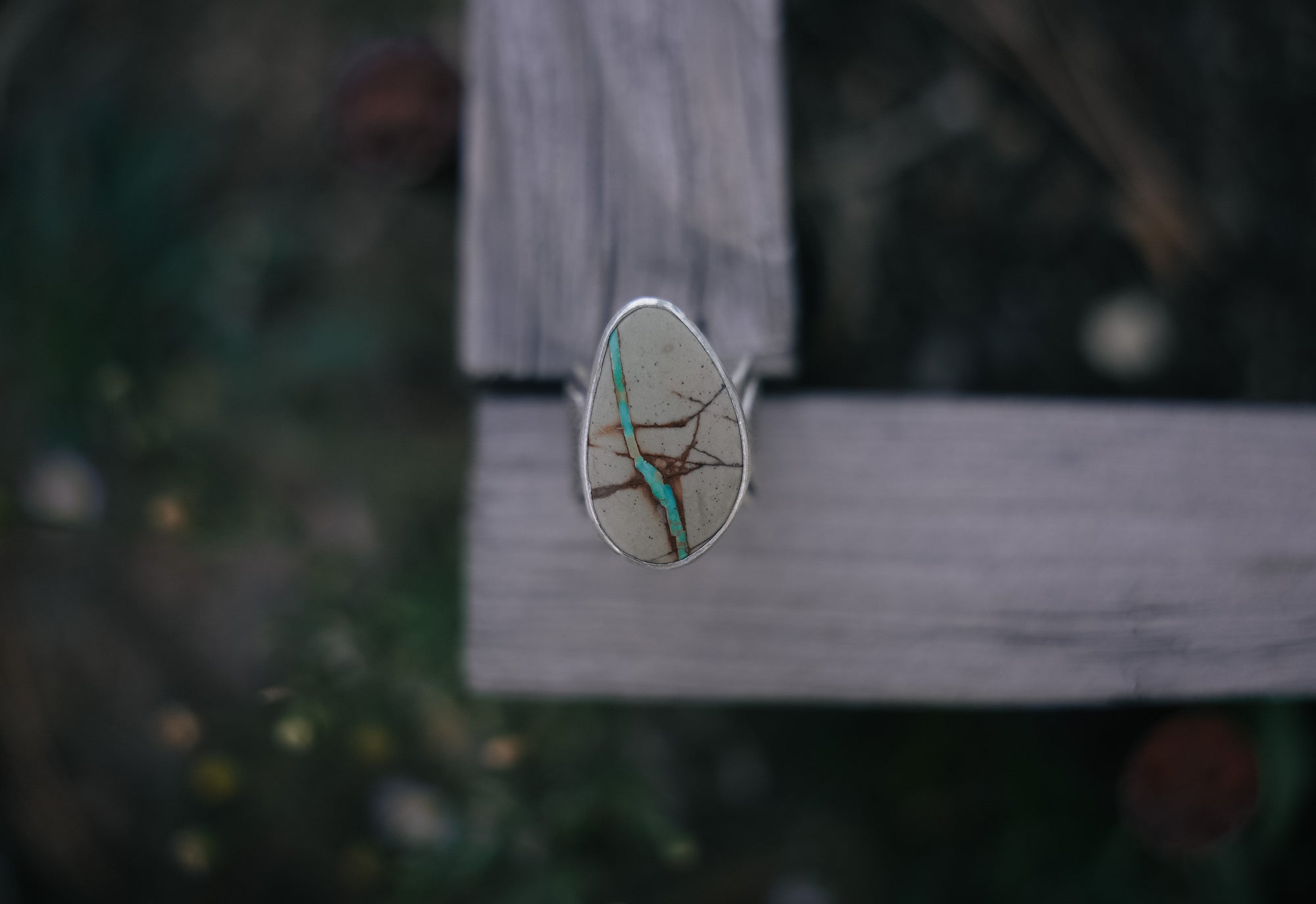 Sterling silver and Royston Ribbon turquoise ring on a wooden surface